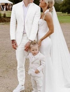 a man and woman standing next to each other in front of a white wedding dress