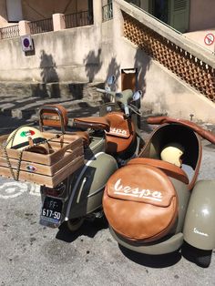 an old motorcycle is parked on the side of the road next to a wooden box