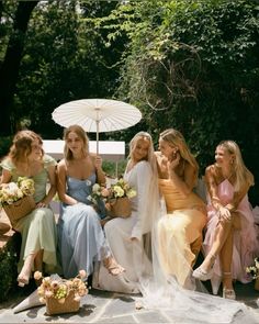 the bridesmaids are all dressed in pastel dresses