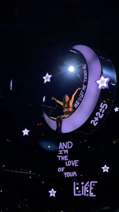 a woman on top of the moon with her arms in the air and stars all around