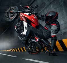 a man riding on the back of a red and white motorcycle in an underground tunnel