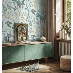 a room with a green cabinet and wallpaper on the walls, next to a window