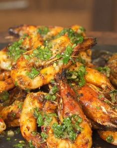 grilled shrimp with herbs on a black plate