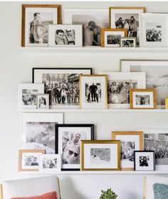 the wall is filled with pictures and frames on it's sides, along with two chairs