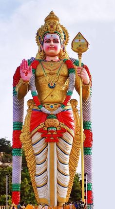 a large statue of a god in front of a building