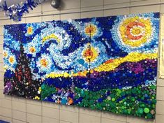 a painting made out of bottle caps on the side of a wall in a building