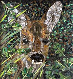 a mosaic portrait of a deer surrounded by green leaves and grass, with the face of a fawn