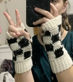 a woman taking a selfie with her cell phone wearing knitted arm warmers