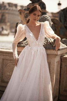 a woman in a wedding dress leaning against a wall