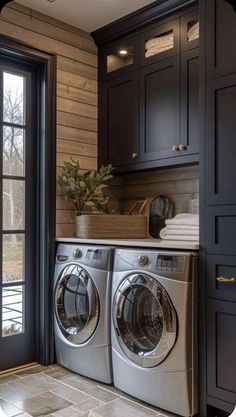 a washer and dryer in a room with dark wood paneling on the walls