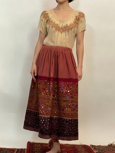 "60's boho dusty rose embroidered cotton skirt, embroidered w/ mirrors and sequins, 1 layer of dusty rose cotton, second layer of maroon w/ embroidery and mirrors, third layer is purple w/ bird embroidery and sequins, has some weight, adjustable string, gathering at the waist. Size S, Waist 14.5\", length 31\", Etsy Shipping -Vintage and pre-owned items may have signs of wear and use and are offered as is. Traces of age and use are therefore completely normal and do not constitute defects. Pleas Rockabilly Skirt, Yellow Pencil Skirt, Flowy Jumpsuit, Plaid Wool Skirt, Poodle Skirt, Bird Embroidery, Wool Wrap, Purple Plaid, Straight Skirt