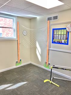 an empty room with some balls on the wall and a net in the corner,