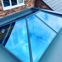 a house with a skylight on the roof and brick building in the back ground