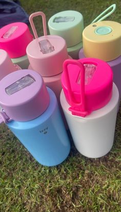 many different colored cups sitting in the grass