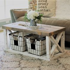 a coffee table with baskets underneath it and flowers in the centerpieces on top