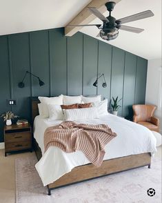 a bedroom with a bed, ceiling fan and two lamps on either side of the bed