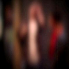 blurry image of a person's arm and hand with red tie on it