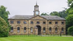 an old building with a clock tower in the middle of it's front yard