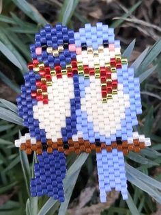 a blue and white beaded ornament with two birds on it's back