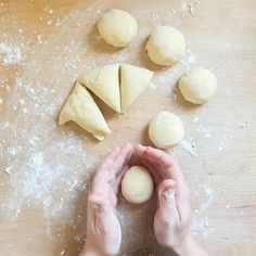 a person is making dough on a table with their hands in front of the dough