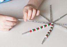 a child is making a star made out of candy canes with glitter on it