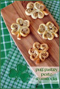 puff pastry pesto shamrocks on a wooden cutting board with green plaid tablecloth