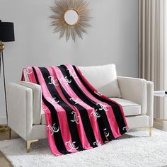 a living room with a white couch and black and pink blanket