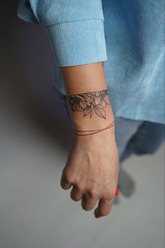 a woman's wrist tattoo with flowers on it