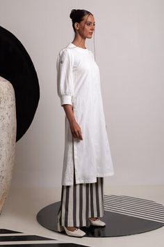 Ivory handwoven cotton kurta featuring a round neckline and floral thread embroidery. Paired with striped flared pant for a coordinated look., Fit: Relaxed White Cotton Kurta With Relaxed Fit, Handloom Cotton Kurta For Spring, Spring Handloom Cotton Kurta, Cotton Kurta In Off White For Spring, Spring Cotton Handloom Kurta, White Relaxed Fit Cotton Kurta, White Cotton Relaxed Fit Kurta, White Kurta For Spring Daywear, White Handloom Cotton Kurta