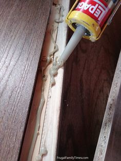 a can of glue is being used to paint wood