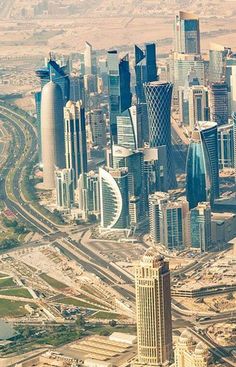 an aerial view of a city with skyscrapers and roads in the middle of it