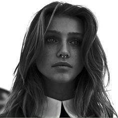 a black and white photo of a woman with long hair wearing a collared shirt