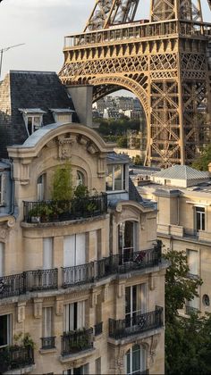 the eiffel tower towering over other buildings in paris, with balconies