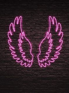 two neon wings on a brick wall