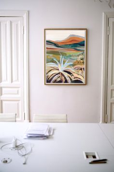 a painting hanging on the wall above a table