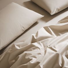 pillows and sheets on a bed with white sheets