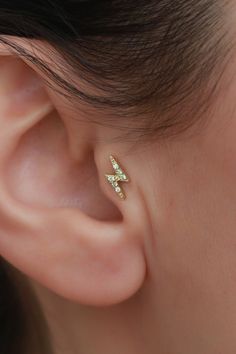 a close up of a person wearing a pair of ear piercings with diamonds on them