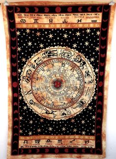 a tapestry hanging on the wall in front of a white wall with stars and moon symbols