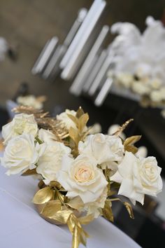 a bouquet of white roses sitting on top of a table