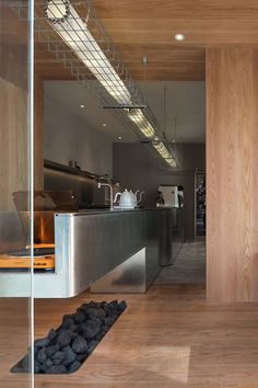 an open kitchen and dining area with wood paneling, stainless steel counter tops and floor to ceiling windows