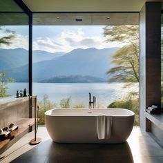 a large bathtub sitting in the middle of a bathroom next to a window with mountains in the background