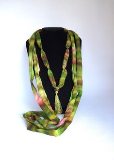 Long necklace in chartreuse green and pink hand-painted silk This necklace is made with silk scraps from my scarves. It is made of 3 different necklaces, to wear together or separately The two largest can be worn as a cuff bracelet I added on the smallest necklace, a chartreuse green pompom topped with a wooden bead, which gives it a chic bohemian side * 100% silk * Necklace length: 194 cm * Width: 3 cm * High quality French paintings *Heat fixed to preserve colors * Made in Lyon * green, chartreuse green, spring green, brown  Wedding Anniversary, Birthdays Packaging : Ready for gifting - carefully packaged in natural tones tissue paper and business card Sending : by tracked letter for France and by registered parcel for international destinations Packaging : carefully packaged in tissue p Artisan Green Hand Painted Necklaces, Green Hand Painted Artisan Necklace, Artisan Hand Painted Green Necklace, Artisan Green Hand Painted Necklace, French Paintings, Silk Necklace, Chartreuse Green, Small Necklace, Brown Wedding