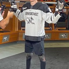 a young man holding up his hockey equipment