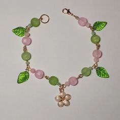 a bracelet with green leaves and pink beads