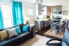 a living room filled with furniture next to a kitchen and dining room table in front of a window