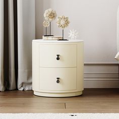 a white cabinet with two flowers on top