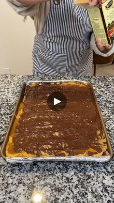 a woman in an apron is making a chocolate cake