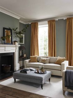 a living room filled with furniture and a fire place in front of a large window