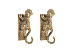 pair of brass monkey hooks on white background