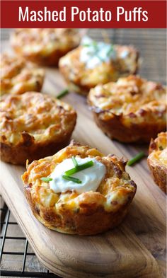 baked mashed potato puffs with sour cream on top and green onions in the background